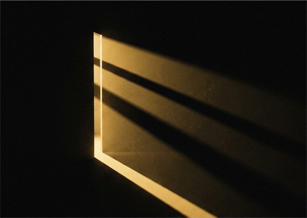 Hard light through a narrow gap, throwing long parallel bars of shadow.